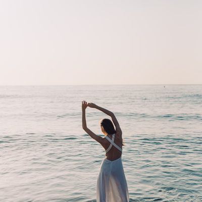 Silhouette of a person standing in a balanced, calm pose against a sunrise.